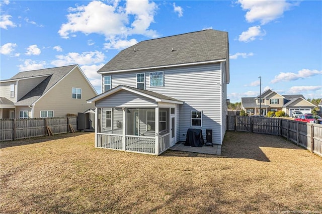 back of house featuring a lawn and a sunroom