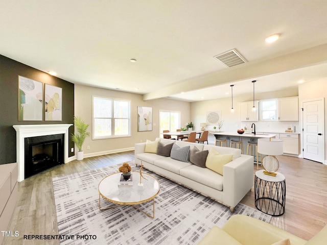 3963 Baileys Xrds Rd, Benson, NC 27504 - living area featuring light wood-type flooring, healthy amount of natural light, recessed lighting, a fireplace, and baseboards