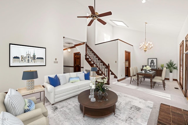 living room featuring ceiling fan with notable chandelier, high vaulted ceiling, and light carpet