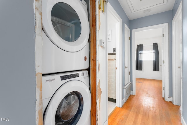 washroom featuring stacked washer and dryer and light hardwood / wood-style floors