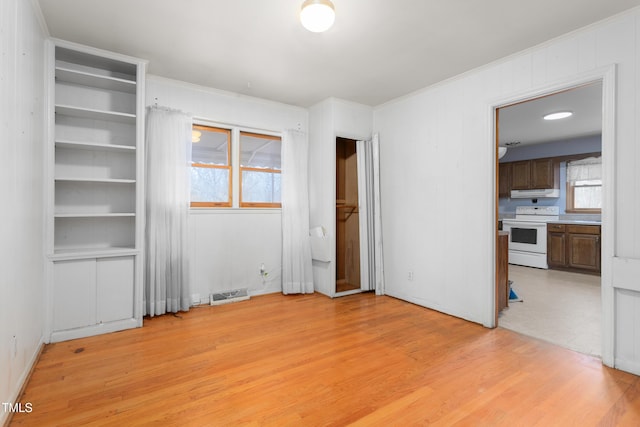 unfurnished bedroom featuring ornamental molding, light hardwood / wood-style floors, and ensuite bathroom