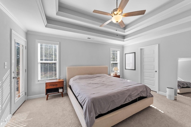 carpeted bedroom featuring a raised ceiling, multiple windows, and access to outside