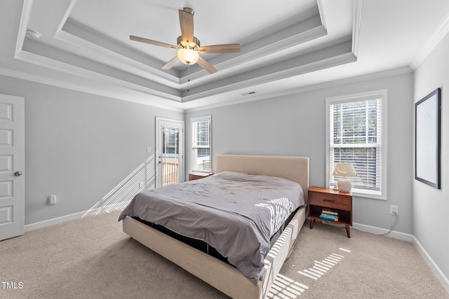 bedroom with carpet floors, ornamental molding, and a raised ceiling