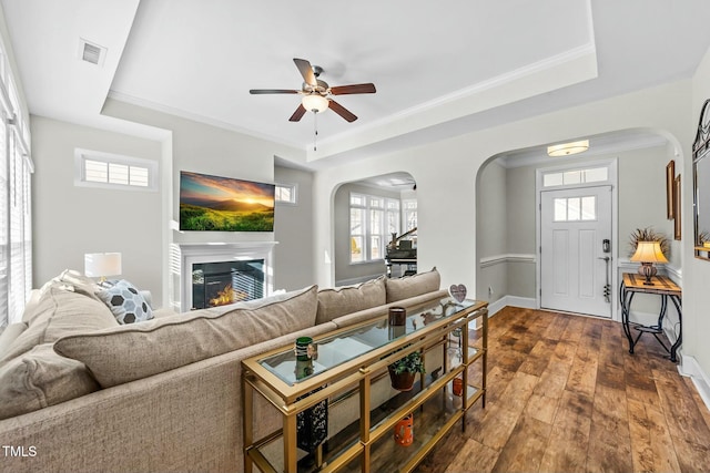 65 Balsam Ln, Clayton, NC 27527 - living area featuring arched walkways, dark wood finished floors, ceiling fan, a glass covered fireplace, and healthy amount of natural light