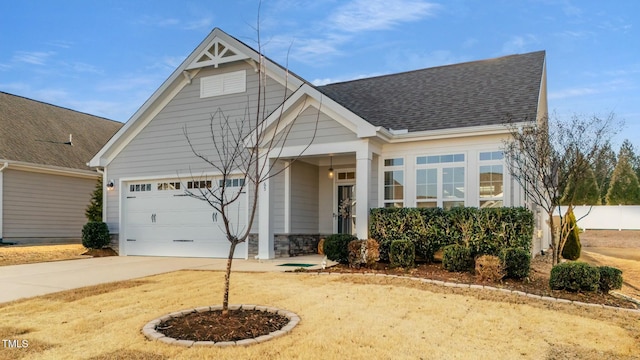 view of front of home featuring driveway, an attached garage, and roof with shingles