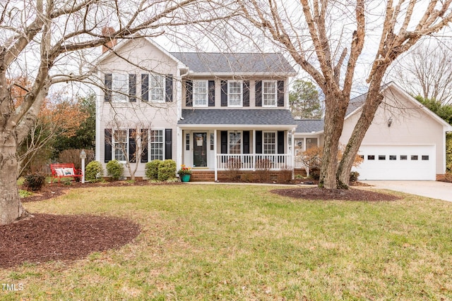 colonial house with a porch, a garage, and a front yard