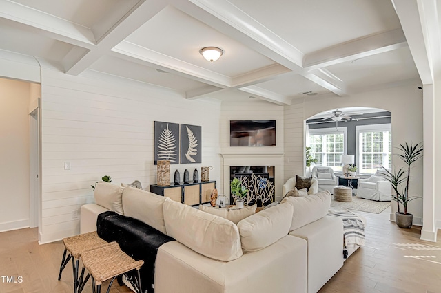 living room featuring coffered ceiling, beam ceiling, and light hardwood / wood-style floors