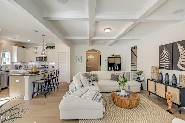 living room with coffered ceiling, beam ceiling, and light hardwood / wood-style floors