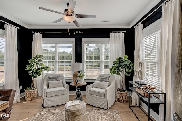 sitting room with ornamental molding, ceiling fan, and light wood-type flooring