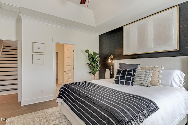 bedroom with wooden walls and light wood-type flooring