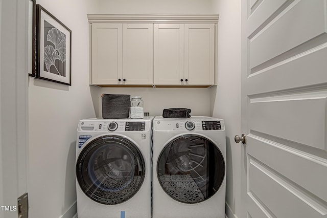 clothes washing area with cabinets and independent washer and dryer