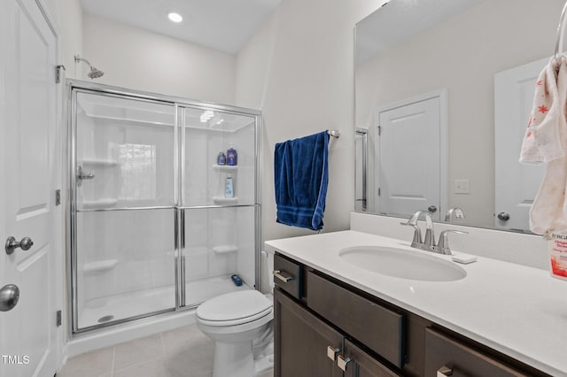 bathroom featuring a stall shower, vanity, toilet, and tile patterned floors