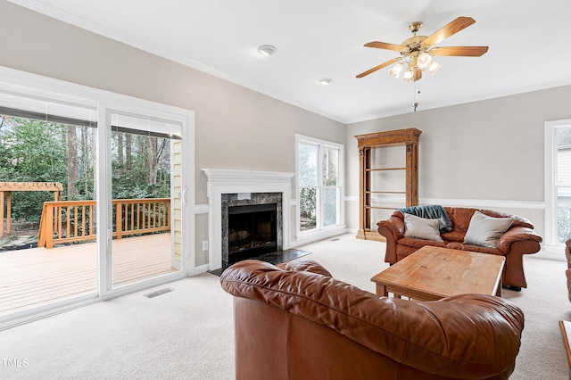 living room with crown molding, light carpet, and a fireplace