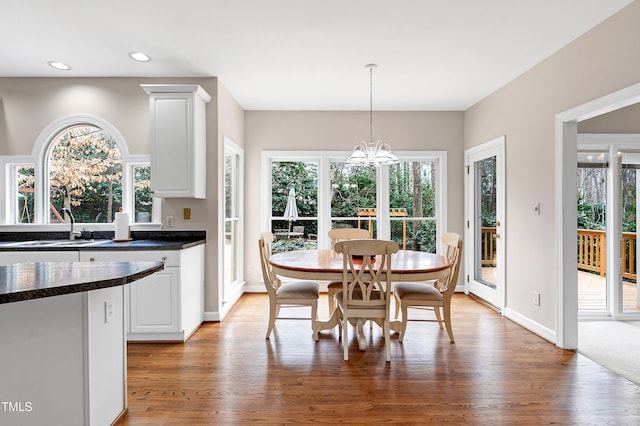 dining room featuring wood-type flooring, plenty of natural light, and an inviting chandelier