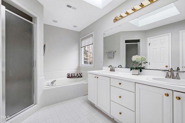 bathroom with vanity, a skylight, tile patterned floors, and independent shower and bath