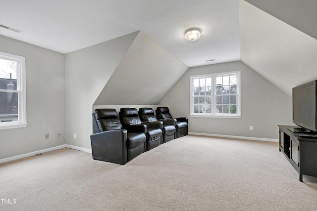 cinema room with lofted ceiling and light colored carpet