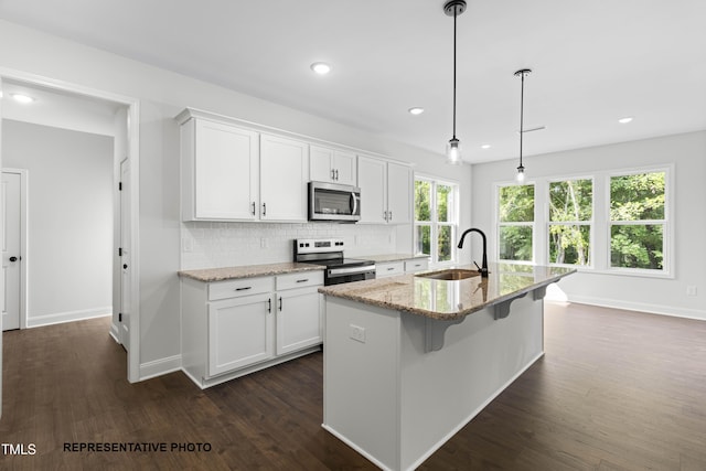 kitchen featuring a sink, decorative backsplash, stainless steel appliances, white cabinetry, and dark wood-style flooring