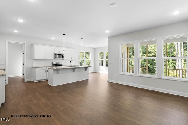 kitchen featuring recessed lighting, dark wood-style floors, white cabinets, stainless steel appliances, and a sink