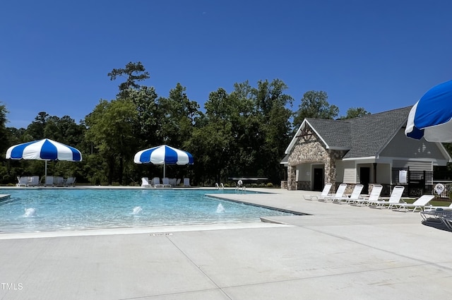 pool with a patio and fence