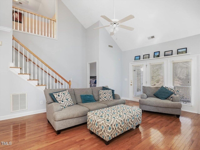 living room with ceiling fan, wood-type flooring, and high vaulted ceiling