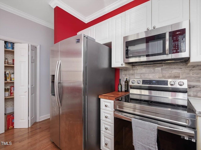 kitchen with crown molding, tasteful backsplash, wooden counters, stainless steel appliances, and white cabinets