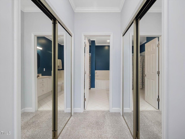 hallway featuring ornamental molding and light colored carpet