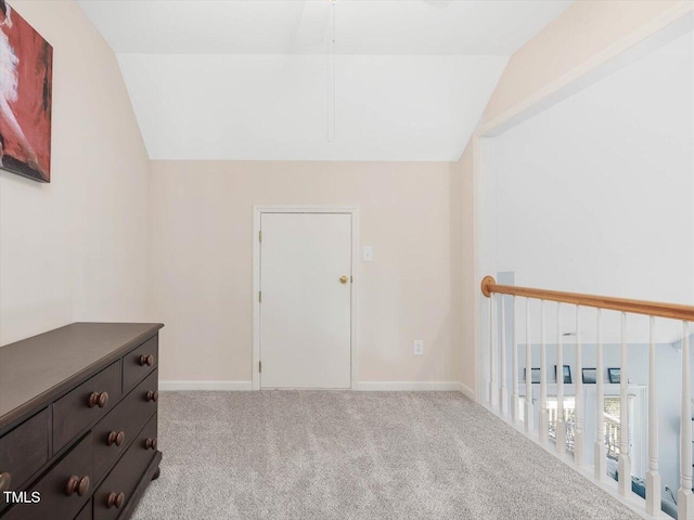 interior space featuring lofted ceiling and light carpet