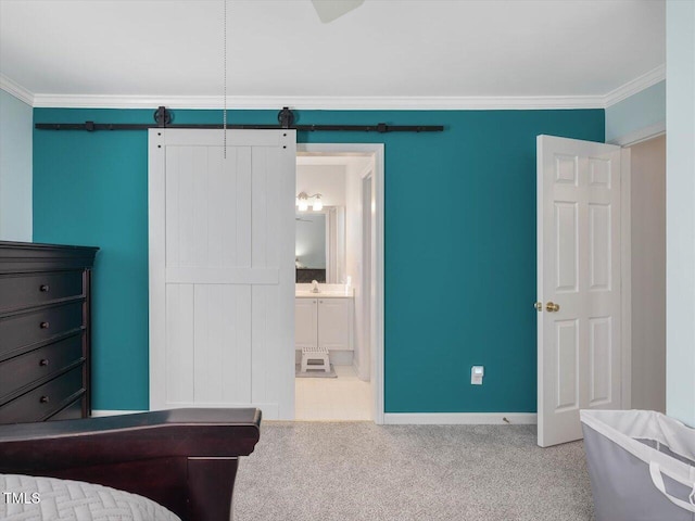 bedroom featuring ornamental molding, light colored carpet, a barn door, and ensuite bathroom