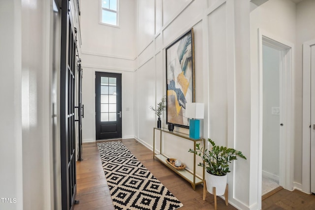 foyer with hardwood / wood-style flooring and a towering ceiling