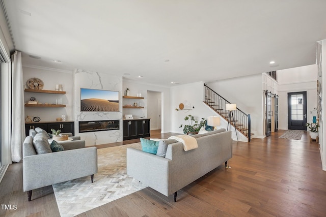 living room featuring hardwood / wood-style flooring, crown molding, and a premium fireplace