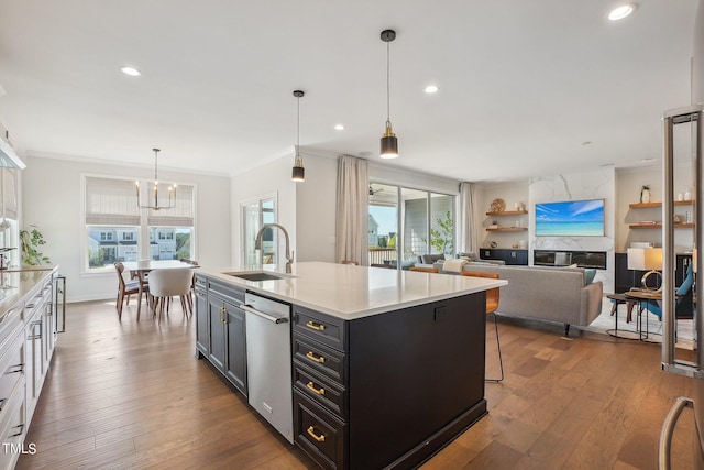 kitchen featuring dark hardwood / wood-style floors, decorative light fixtures, an island with sink, sink, and stainless steel dishwasher