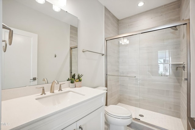 bathroom with vanity, a shower with shower door, and toilet