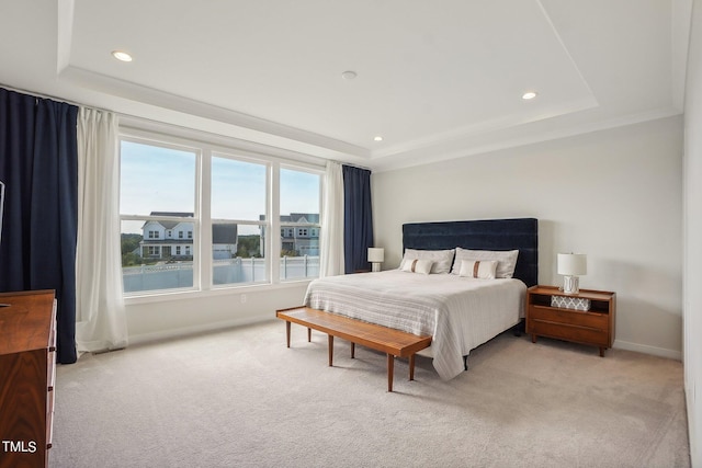 bedroom featuring light colored carpet and a raised ceiling