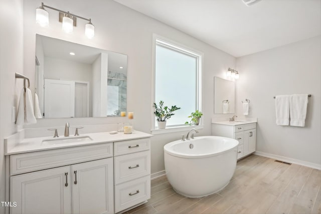 bathroom with vanity, hardwood / wood-style flooring, and a bathing tub