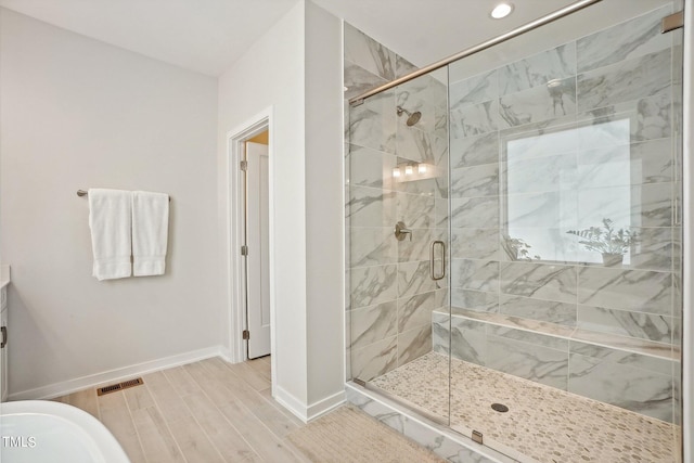 bathroom featuring hardwood / wood-style flooring and a shower with shower door