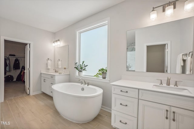 bathroom featuring vanity, hardwood / wood-style flooring, and a tub