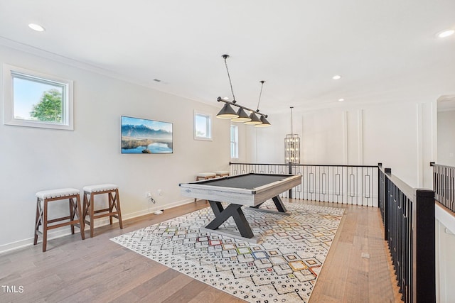 playroom with ornamental molding, plenty of natural light, light hardwood / wood-style floors, and a chandelier