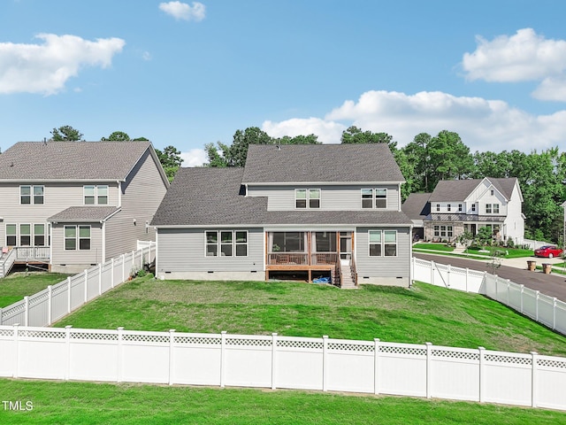 back of property featuring a wooden deck and a lawn