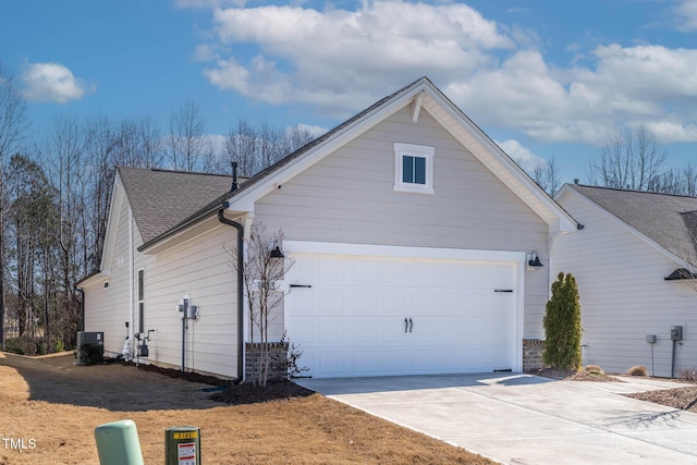 view of property exterior with a garage, concrete driveway, central AC unit, and roof with shingles