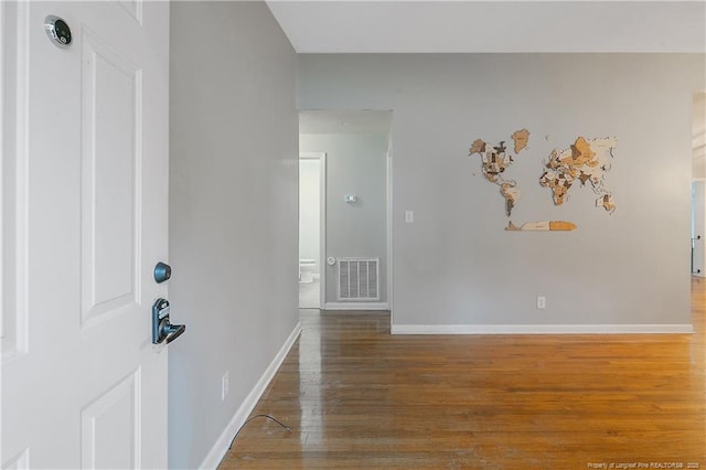 unfurnished room with visible vents, baseboards, and wood finished floors