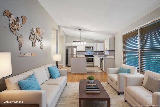 living room with lofted ceiling and light wood-style flooring