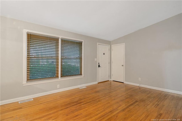 4442 Wellington Dr, Fayetteville, NC 28314 - unfurnished room featuring visible vents, vaulted ceiling, baseboards, and wood finished floors