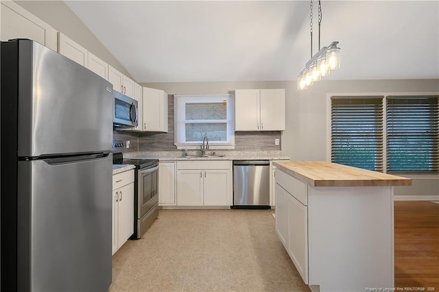 4442 Wellington Dr, Fayetteville, NC 28314 - kitchen with a sink, white cabinets, vaulted ceiling, wooden counters, and appliances with stainless steel finishes