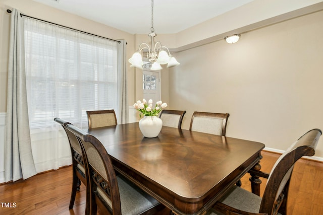 dining space with dark hardwood / wood-style flooring and a chandelier