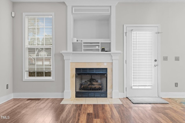 unfurnished living room featuring hardwood / wood-style floors and a tile fireplace