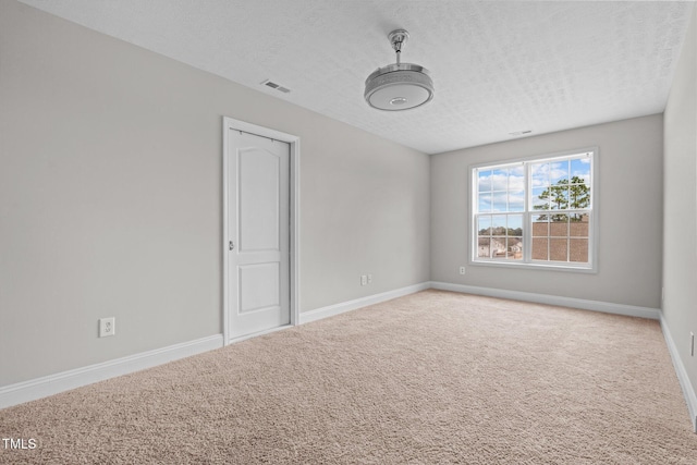 carpeted spare room featuring a textured ceiling