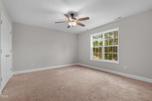 carpeted spare room with ceiling fan and a textured ceiling