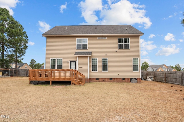 back of property featuring a wooden deck and a lawn