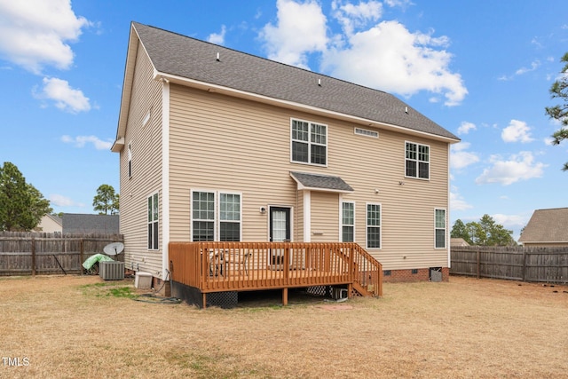 rear view of property featuring a wooden deck and a lawn