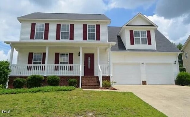 view of front of property featuring a garage, a front yard, and a porch